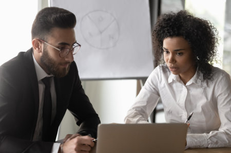 man and woman looking on laptop
