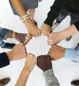Different races doing fist bumps forming a circle