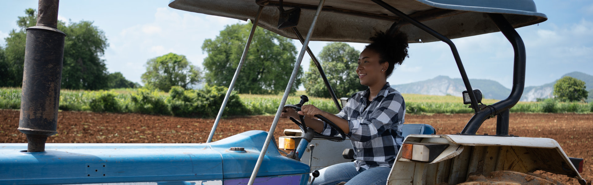 Young beautiful black woman working on a tractor