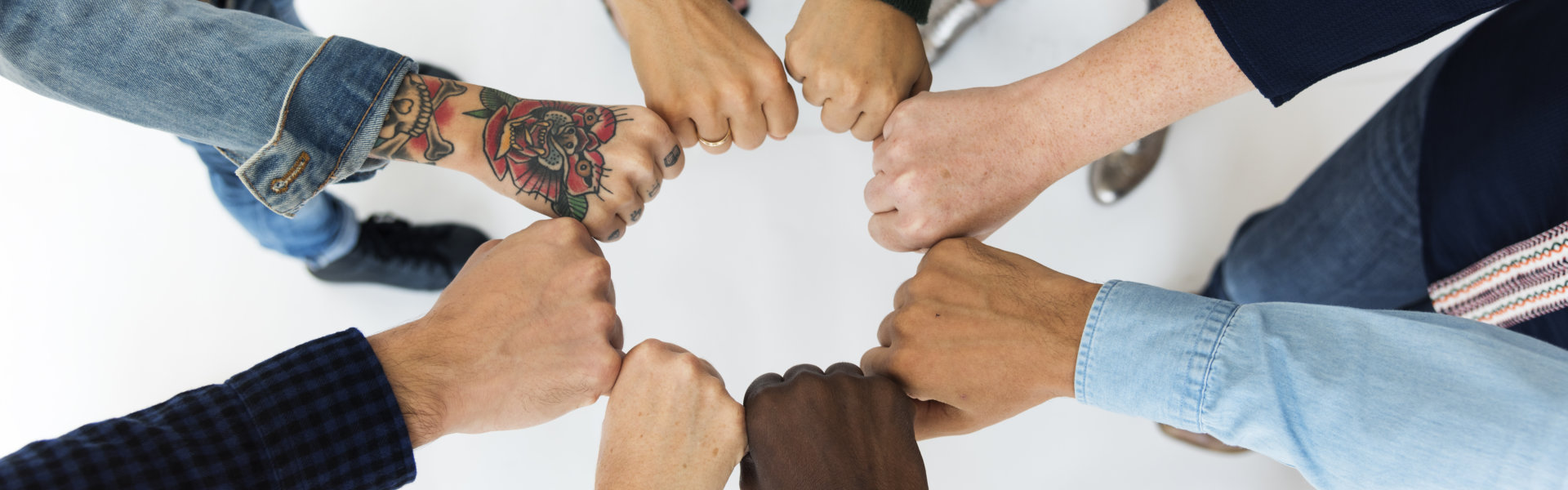 Different races doing fist bumps forming a circle